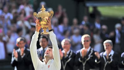 Novak Djokovic holds the winner's trophy in 2014 after beating Roger Federer. AFP