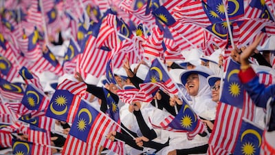 Students wave national flags during the National Day parade in Putrajaya, Malaysia. AP Photo