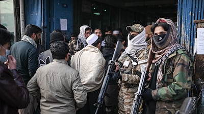 Taliban fighters stand guard in front of the entrance of the money exchange Sarai Shahzada market in Kabul on December 20, 2021. AFP