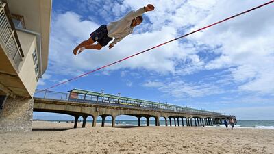 Slackliner Sandor Nagy practices on the beach in Boscombe, on the south coast of England. AFP