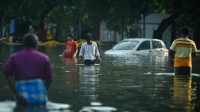 People wade through a flooded street after incessant heavy rains in Chennai, Tamil Nadu. EPA