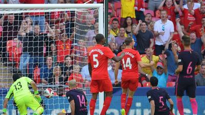 Liverpool midfielder Jordan Henderson begins to celebrate after Javier Mascherano’s own goal hands Liverpool a 2-0 lead. Glyn Kirk / AFP