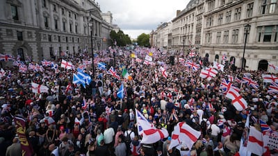 Protesters wave British Union, St George's and Saltire flags during the Unite The Kingdom rally in Whitehall on September 13, 2025 in London. Organiser and far-right activist Tommy Robinson and his supporters are actively Islamaphobic and racist and have been behind much of the unrest seen outside hotels housing migrants this summer. Getty Images