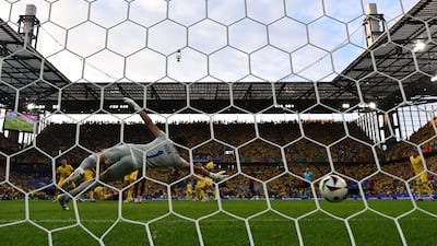 Romania goalkeeper Florin Nita dives but is beaten by Youri Tielemans' shot. AFP