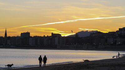 People walk their dogs in Ondarreta beach at sunrise in San Sebastian, Basque Country, northern Spain. EPA
