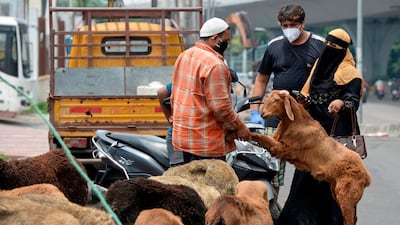 A couple purchases a goat from a roadside trader in Hyderabad. AFP