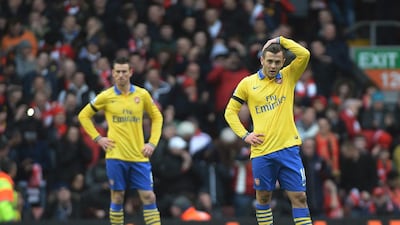 Arsenal midfielder Jack Wilshere, right, looks dejected after his side were beaten 5-1 at Anfield by Liverpool. Peter Powell / EPA