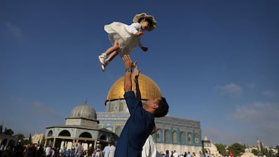 A Palestinian man throws his child in the air following morning prayers marking the first day of Eid al-Adha celebrations, on the compound known to Muslims as al-Haram al-Sharif and to Jews as Temple Mount in Jerusalem's Old City. Reuters
