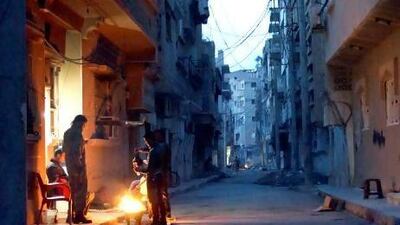 Members of the Free Syrian Army stand around a fire while they guard a neighbourhood in Deir Al Zor. Khalil Ashawi / Reuters