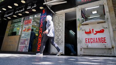 A woman walks in front of currency exchange shops at Hamra street in Beirut. The devaluation of the Lebanese pound has exacerbated inflationary pressures. EPA