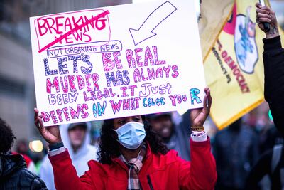 A protester holds a sign about racial injustice during a "Justice for Rittenhouse Victims-Abolish White Supremacy" protest in Minneapolis on November 20. AFP