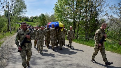 Ukrainian servicemen carry the coffin of a killed soldier, one of many who have died in the conflict with Russia. Reuters