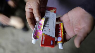 Wu Qiongyao shows the skin ointments which her husband uses for his ulcers at Heshan village. Jason Lee / Reuters
