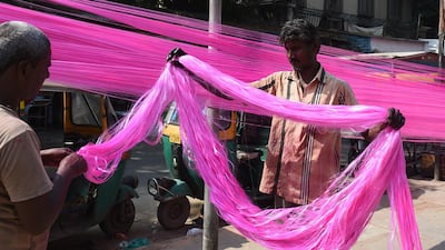 Workers dry out coloured polyster/silk yarn from which garlands are made ahead of the Hindu festival of Diwali in Ahmedabad on October 17, 2019. Colourful garlands are in demand during the Hindu festival of Diwali, or Festival of Lights, which falls on October 27 this year. AFP