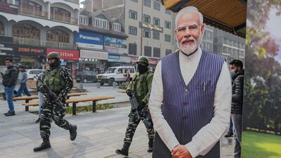 Troops patrol past a cut-out of India's Prime Minister Narendra Modi in Srinagar, Kashmir, as security was increased before the Supreme Court verdict. AFP