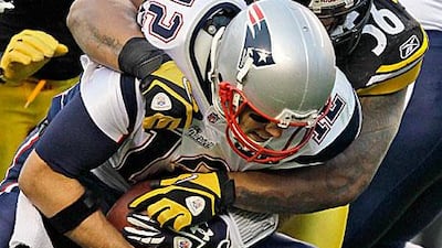 Tom Brady, front, did not see much of the ball against the Pittsburgh Steelers as the linebacker, LaMarr Woodley, sacks the quarterback in the fourth quarter.