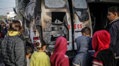 Palestinians inspect the van where five journalists were killed in an Israeli strike in central Gaza. EPA