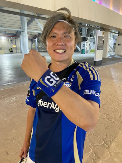 Machida Zelvia supporter Ko Morahashi shows his wrist band celebrating the team's coach, Go Kuroda. Photo: Paul Radley / The National