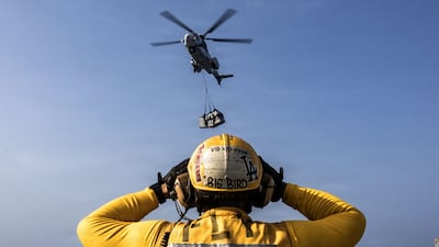 A US Navy sailor directs a helicopter on the flight deck of aircraft carrier USS Abraham Lincoln. Reuters