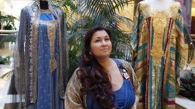 Dr. Reem Mutwali is photographed between a dress previously owned by Sheikha Shamah bint Rashid Bin Khalaf Al 'Utaybah and a dress previously owned by Sheikha Hamda bint Mohammed Al Nahyan. Sarah Dea / The National