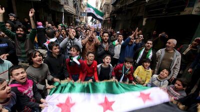 Protesters shout slogans and carry Free Syrian Army flags during an anti-government protest in the Al Sukari neighbourhood of Aleppo, Syria, on March 11, 2016. Abdalrhman Ismail / Reuters