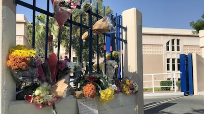 Flowers and soft toys adorn the gates of the school where the accident happened. Antonie Robertson / The National