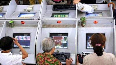 Investors look at computer screens showing stock information at a brokerage in Shanghai. The Shanghai index on Monyda posted its biggest one-day percentage loss since 2007. Aly Song / Reuters