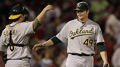 Oakland Athletics starting pitcher Brett Anderson, right, is congratulated by catcher Kurt Suzuki after Anderson pitched a two-hitter in Oakland's 6-0 win over the Boston Red Sox.