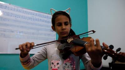 A child plays the violin during a music lesson at the Yemeni House of Music, in Sanaa, Yemen. EPA
