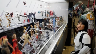 A boy wearing a Stormtrooper costume looks at Star Wars figurines. EPA