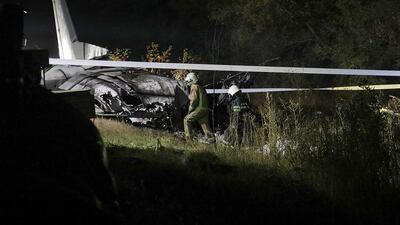 Rescuers inspect the crash site of the AN-26 plane near of Chuguev city of Kharkiv. EPA