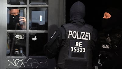 Masked police officers guard the entrance to a building at Wildenbruchstrasse in Berlin's Neukoelln district. AFP
