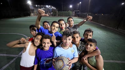 Children pose with a football on the artificially lit pitch during the Champions League final between Tottenham and Liverpool in Liverpool's Mohamed Salah hometown of Negreeg, Egypt. Reuters