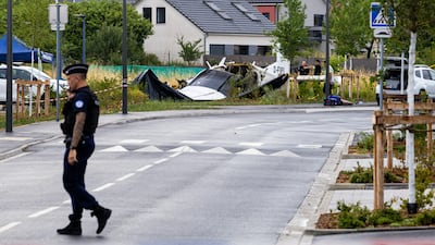 A police officer helps secure the scene of a plane crash in Tomblaine, near Nancy, France. A civilian aircraft carrying skydivers crashed shortly after take-off, killing at least 11 on board. EPA