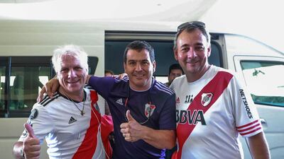 Left to right, River Plate fans Pablo Bajcic, 61, Gustavo Zalazar, 46 and Mauricio Lusso, 49, wait for their shuttle bus to the Hazza Bin Zayed Stadium.