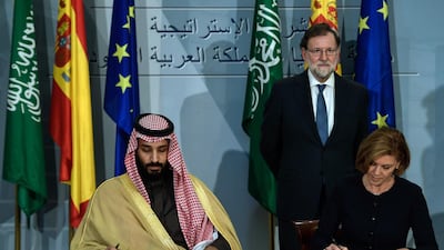 Saudi Arabia's crown prince Mohammed bin Salman (L) and Spanish Minister of Defence Maria Doroles de Cospedal sign agreements as Spanish Pime Minister Mariano Rajoy looks on at La Moncloa palace in Madrid on April 12, 2018. Prince Mohammed arrived in Spain late on April 11, 2018 hot on the heels of a three-day official visit to France and after a tour lasting several weeks of Egypt, the United States and Britain that saw the self-styled moderniser sign multimillion-dollar deals. Madrid is the last stop of his global diplomatic charm offensive in a bid to project a new liberal image of his conservative kingdom. / AFP PHOTO / OSCAR DEL POZO