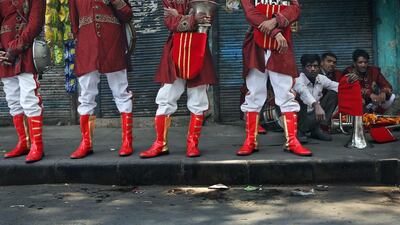 Members of Master Band wait for transportation to leave for work, in New Delhi, India.
