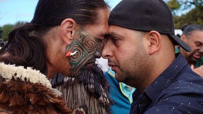 A Muslim man, right, and another local perform a traditional Maori 'hongi' greeting, a touching of noses, during a gathering for congregational Friday prayers and two minutes of silence for victims of the twin mosque massacre, at Hagley Park in Christchurch. AFP