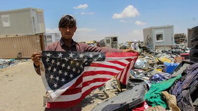 An Afghan man shows a US flag in southern Afghanistan as concerns grow over the protection of translators and others who helped US and Nato forces. EPA