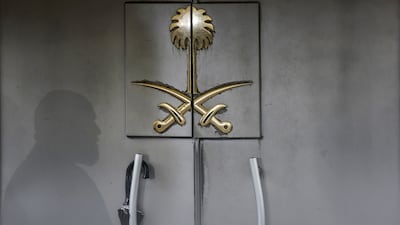 The shadow of a security guard falls on the entrance door of the Saudi Arabia sign. Getty Images