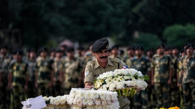 Indian Border Security Force soldiers pay tribute to their colleague Lal Fam Kima during a wreath-laying ceremony in Jammu, India on Thursday. AP