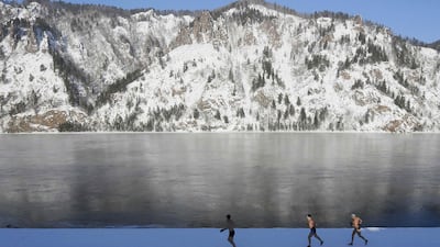 Enthusiasts of winter swimming warm up on the bank of the Yenisei River on January 27, 2017 in -26C temperatures, ahead of their weekly dip in the Siberian town of Divnogorsk, Russia. Ilya Naymushin