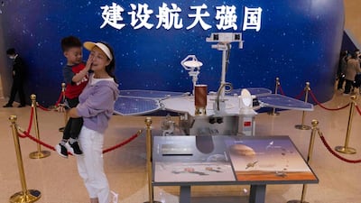 Visitors to an exhibition on China's space program pose for photos next to a life size model of the Chinese Mars rover Zhurong, named after the Chinese god of fire, at the National Museum in Beijing. AP Photo