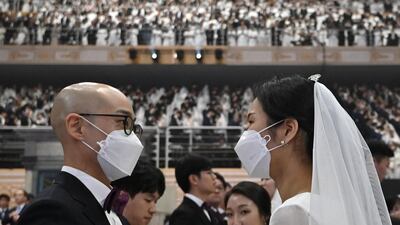 A couple wearing protective face masks attend a mass wedding ceremony organised by the Unification Church at Cheongshim Peace World Center in Gapyeong. AFP