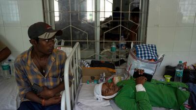 An injured passenger, right, lies in a hospital bed in Balasore, Orissa. AP