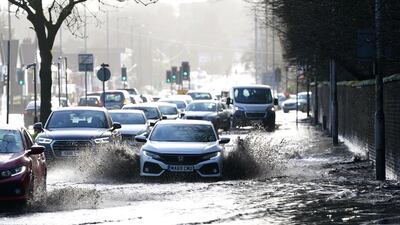 Cars drive through floodwater as hurricane-force winds and rain affected the country's transport network leading to disruptions and prompting warnings of power cuts and a risk to life, in Manchester, Britain. REUTERS