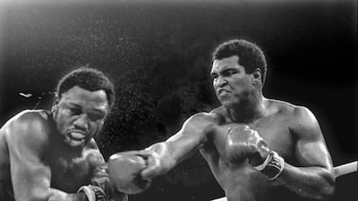In this October 1, 1975, file photo, spray flies from the head of challenger Joe Frazier as heavyweight champion Muhammad Ali connects with a right in the ninth round of their title fight in Manila, Philippines. Mitsunori Chigita / AP photo