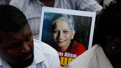 A protester holds a photograph of Indian journalist Gauri Lankesh at a demonstration against her killing in Bangalore on September 6, 2017. Aijaz Rahi / AP