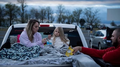 Summer Edwards, Kimberlyn Edwards, and Chance Edwards eat snacks while waiting for the movie to start at the Family Drive-In Theatre in Stephens City, Virginia. AFP