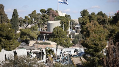 An Israeli flag flutters above demolished structures. The UN says the compound remains its premises despite the demolition. AFP